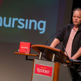 Spreker Sander de Hosson op het podium bij het Jaarcongres Palliatieve Zorg